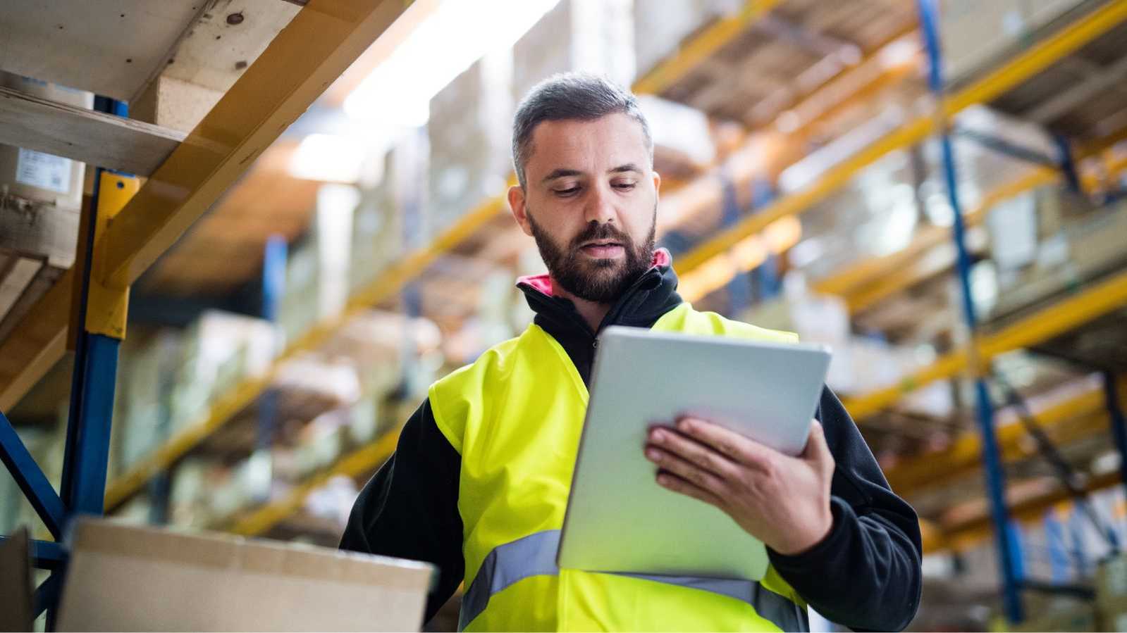 man in warehouse looking at tablet man in warehouse looking at tablet