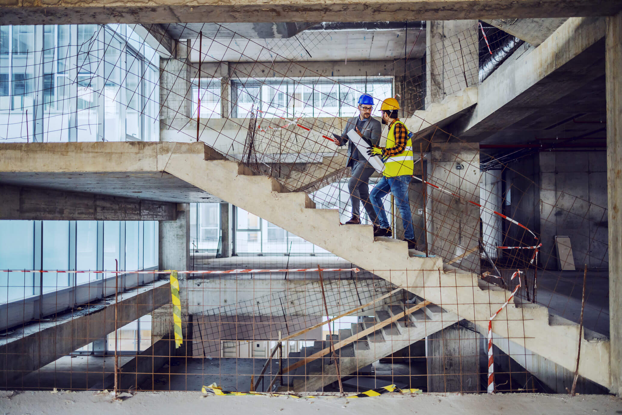 architect and project manager walking up the stairs of a building that is under construction