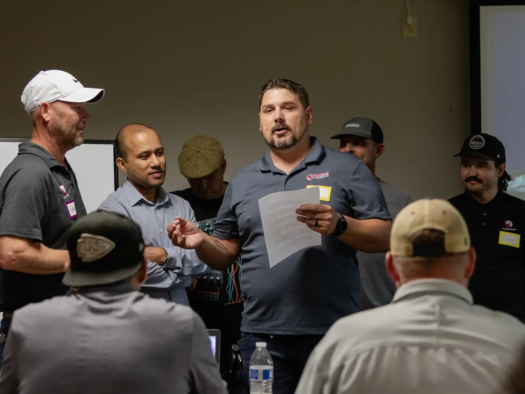 A group of men in casual attire has a lively discussion in a meeting room