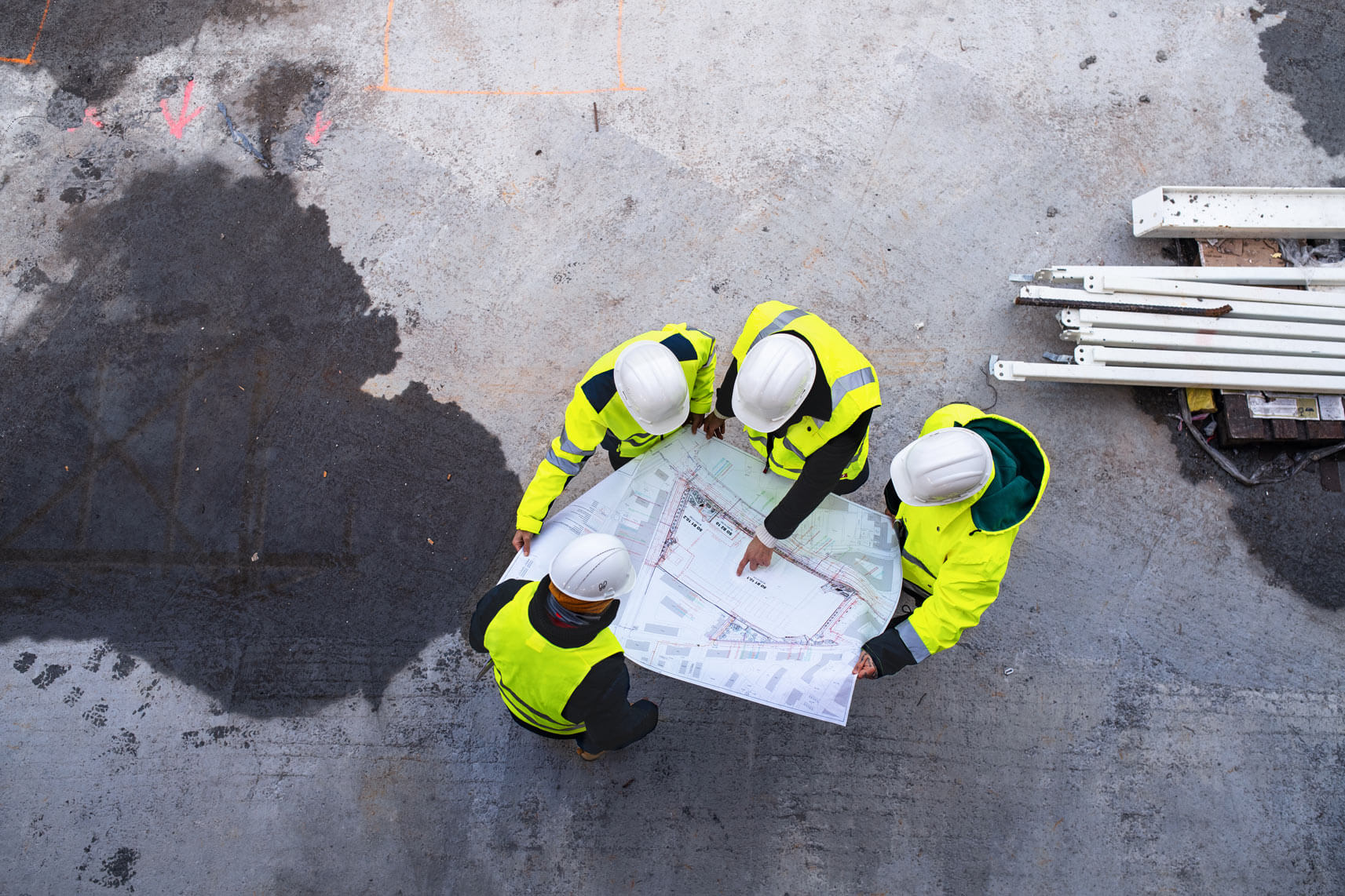 enginners and contractors looking at a blueprint at a job site
