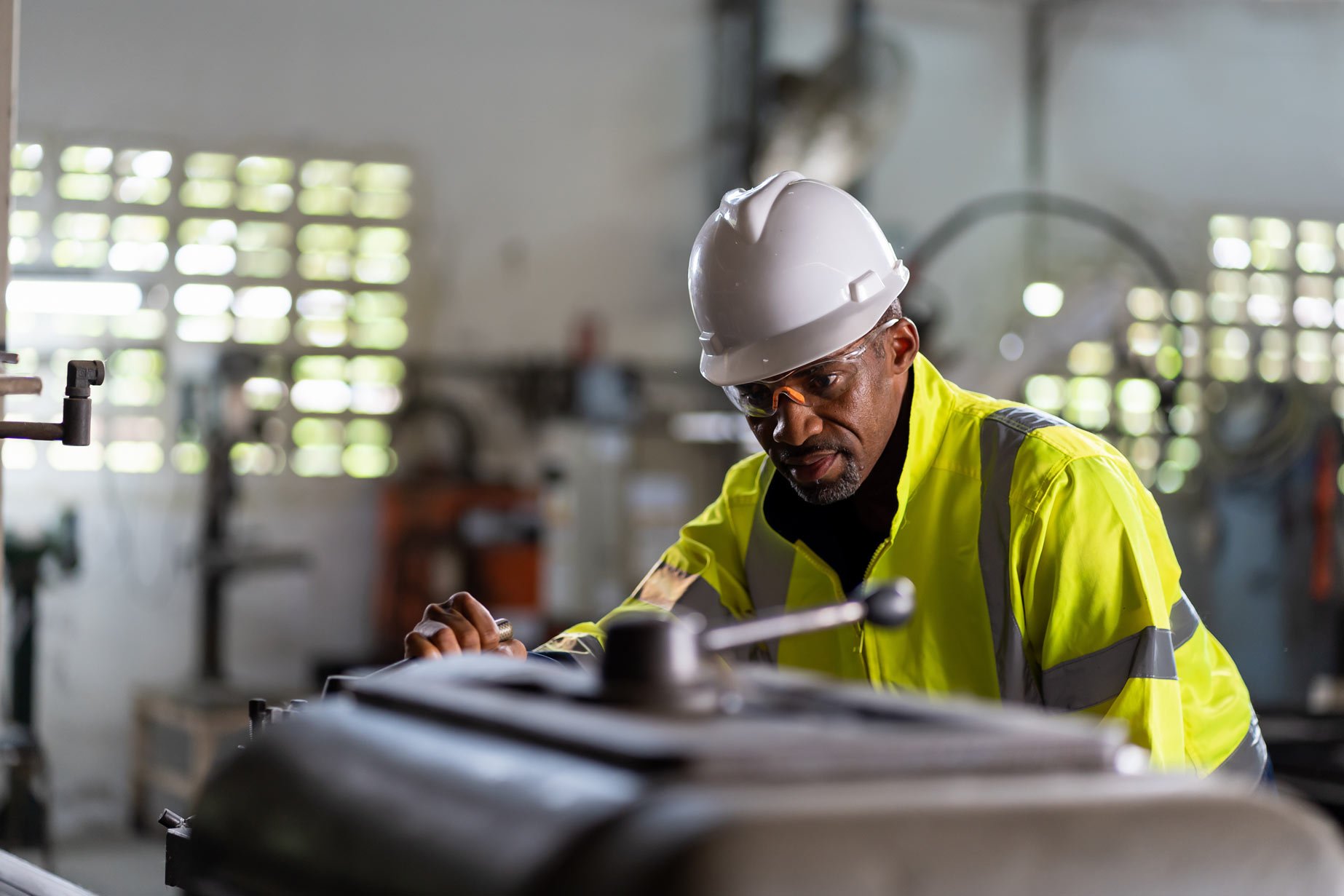manufacturing professional using machinery at a facility