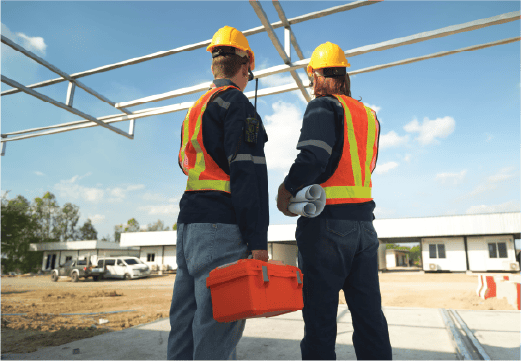 Contractors holding blueprints and toolboxes