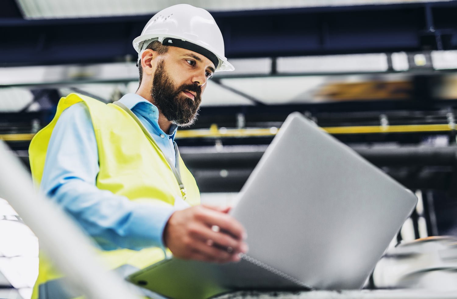 engineer wearing hard hat while working on laptop