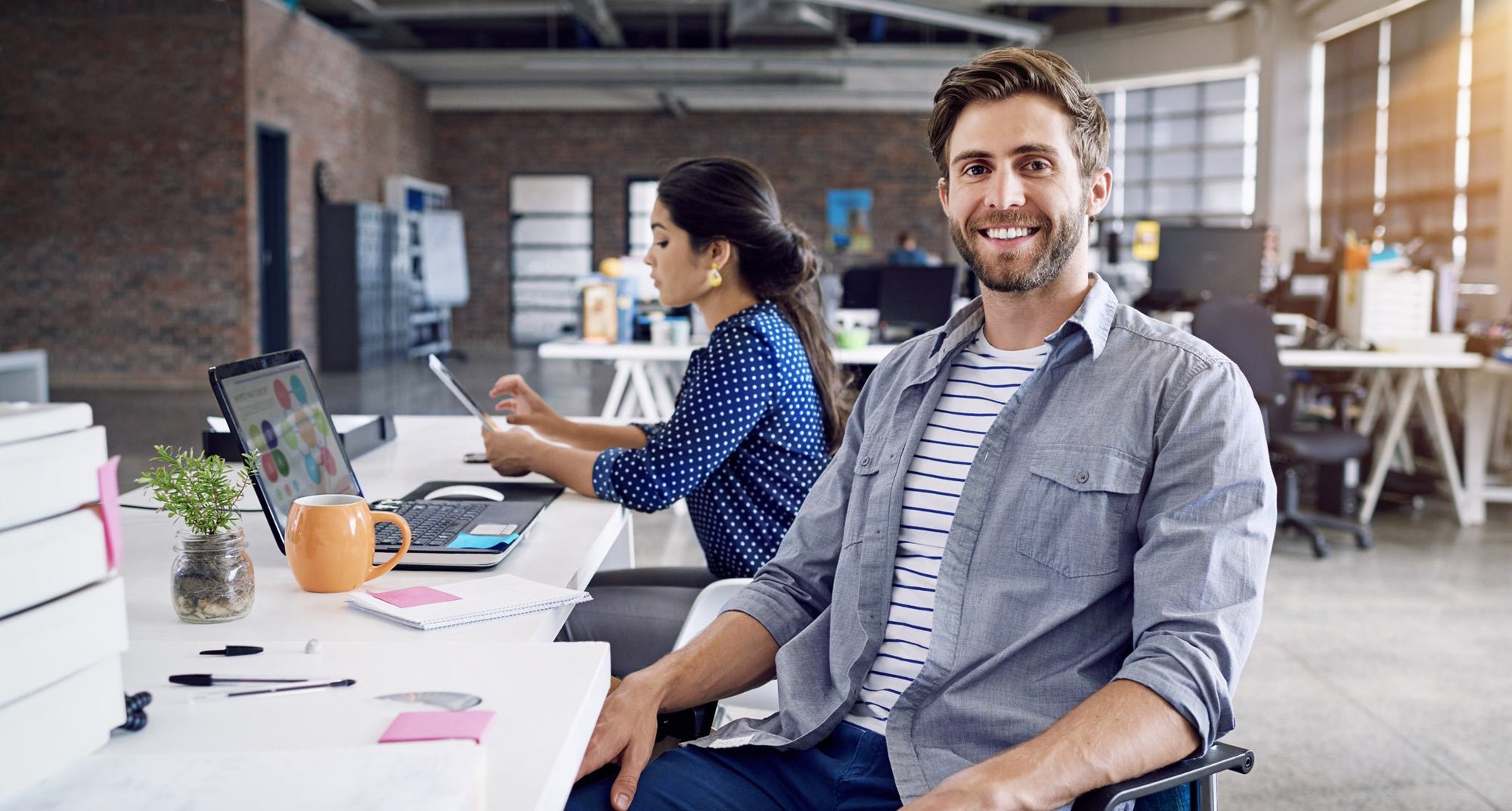 office worker sitting at a desk in an open concept office