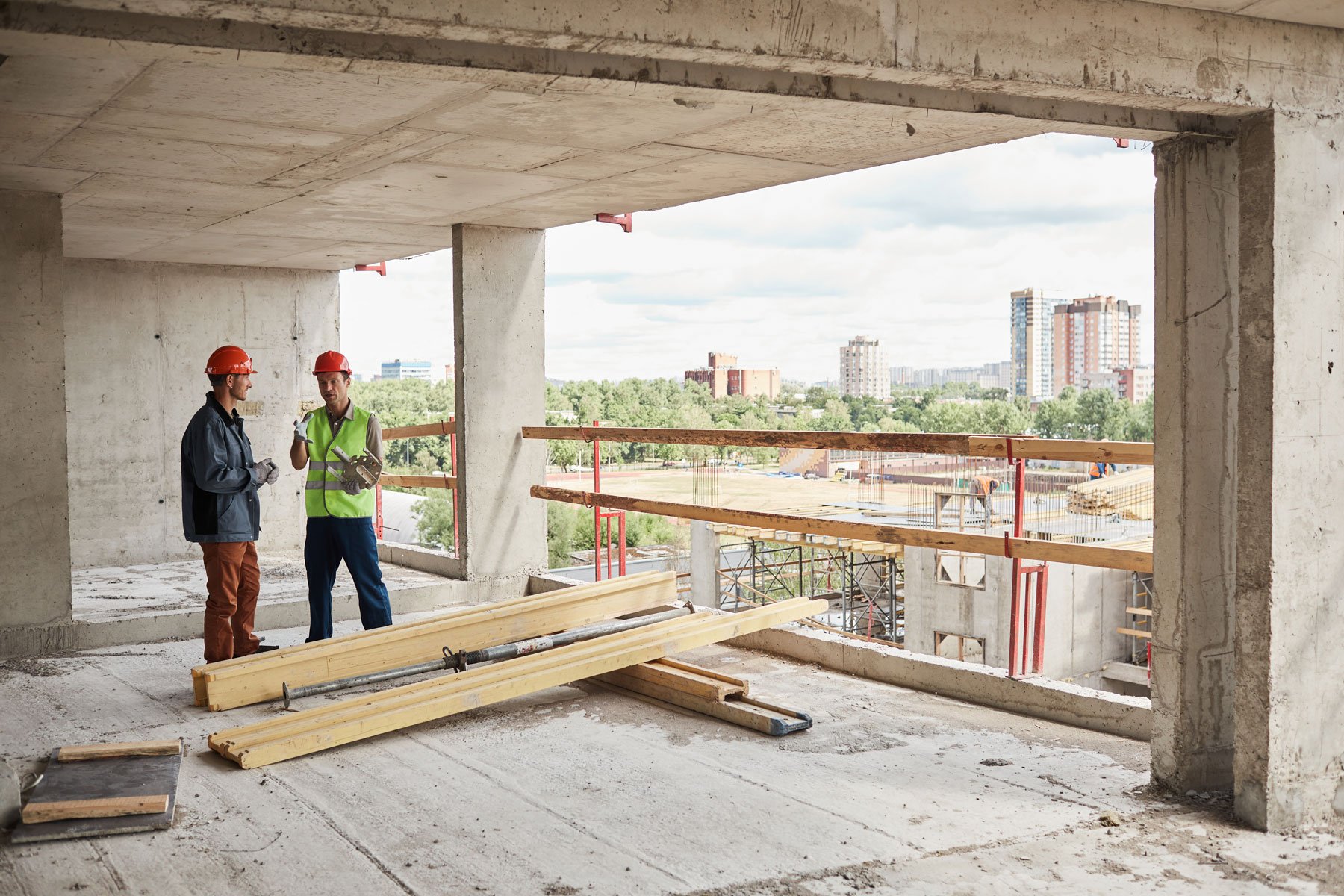 Construction workers standing inside a building under construction