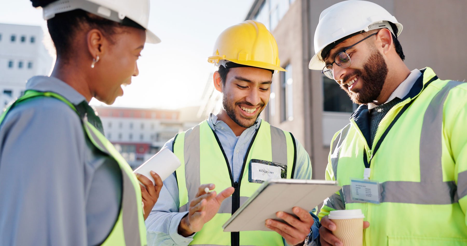 Team of construction engineers, discussing items on a tablet