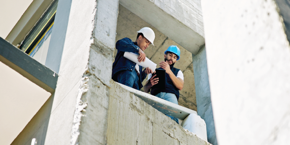 architect and contractor looking at building blueprint