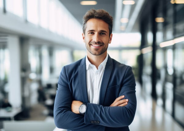 business professional wearing a suit standing in front of an office backdrop