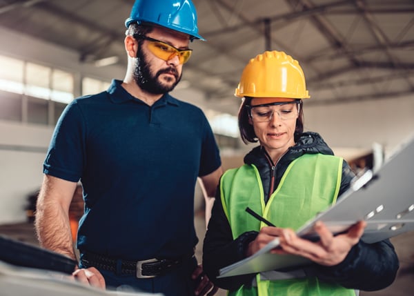 construction colleagues looking at a safety report checklist