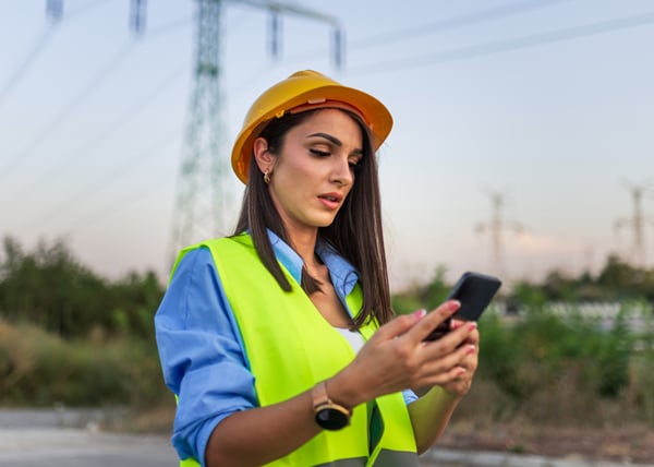 construction site project manager looking at mobile device