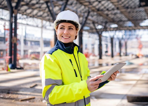 construction worker in the field while holding tablet