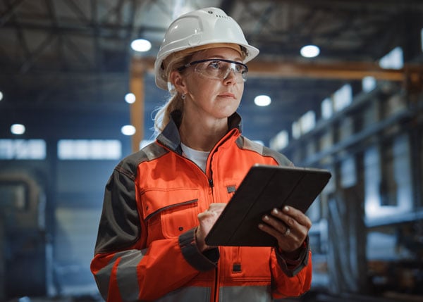 construction worker on site holding a tablet