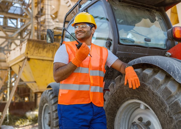 construction worker standing next to heavy machinery