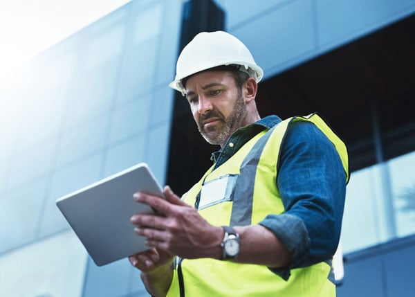 contractor looking at tablet device on site