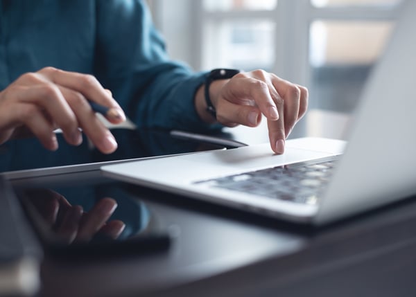 project manager typing on a laptop
