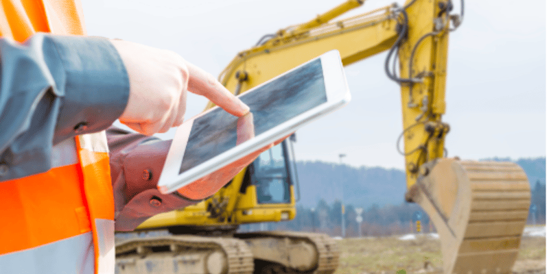 man on construction site with a tablet